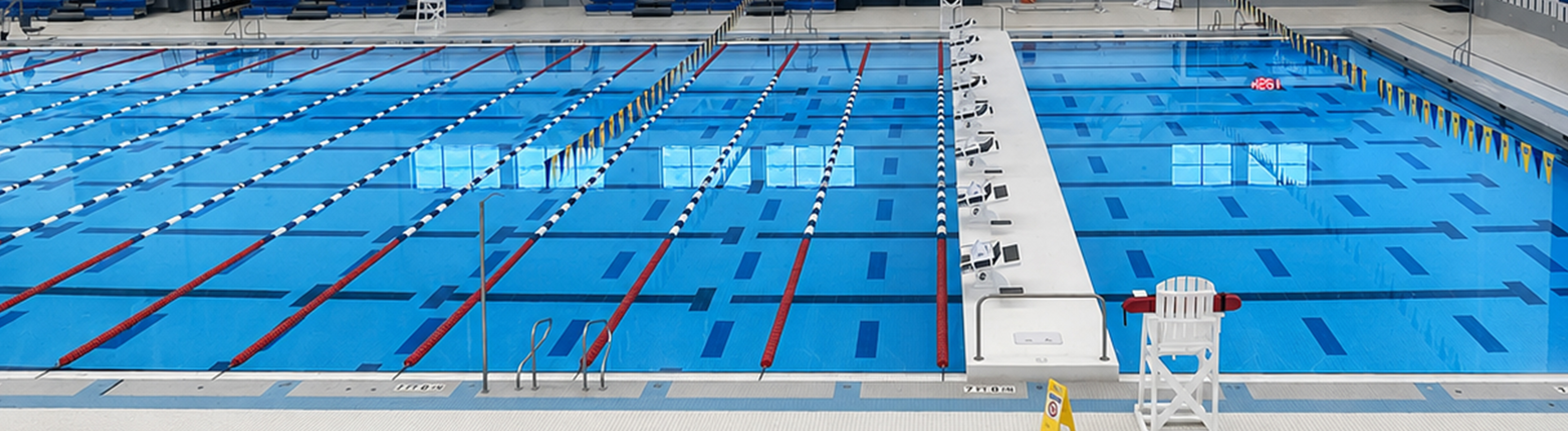 A movable bulkhead installed in a large commercial swimming pool. One side is set up for lap swimming and the other side is set up for leisure swimming or other programming.